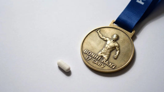 Sports medal with a pill next to it.